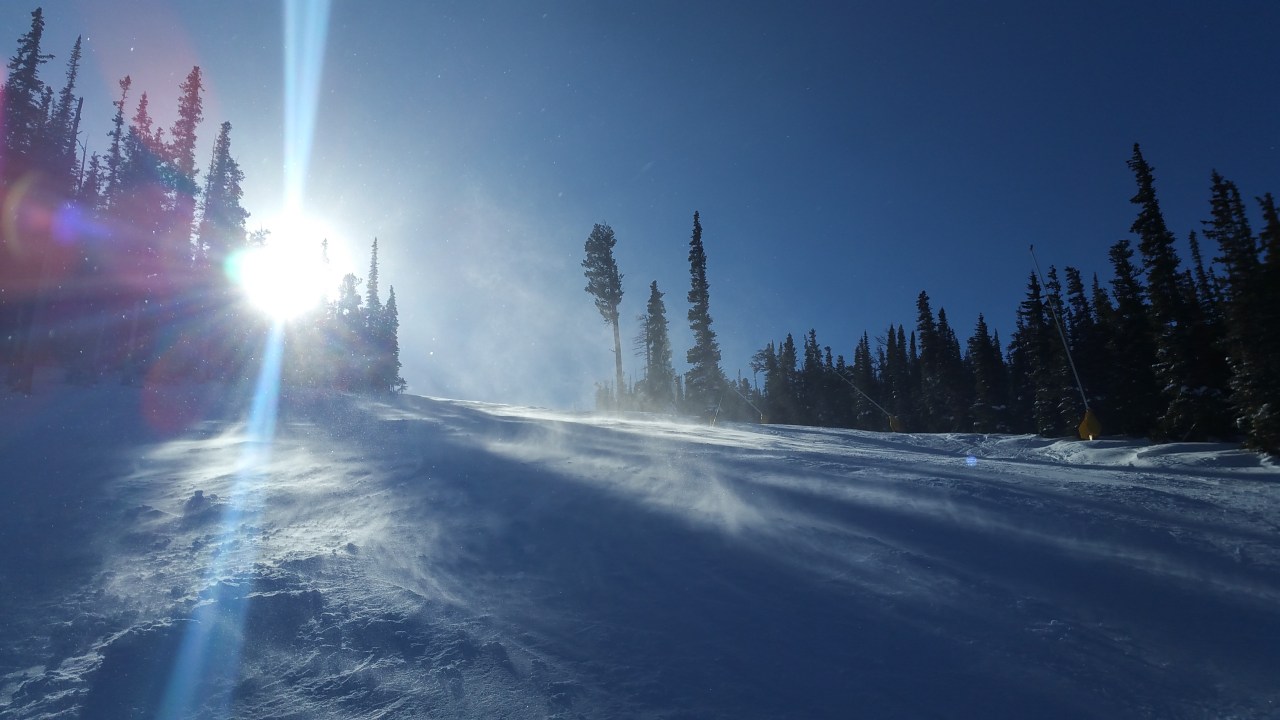 Sunshine and show blowing on a ski run