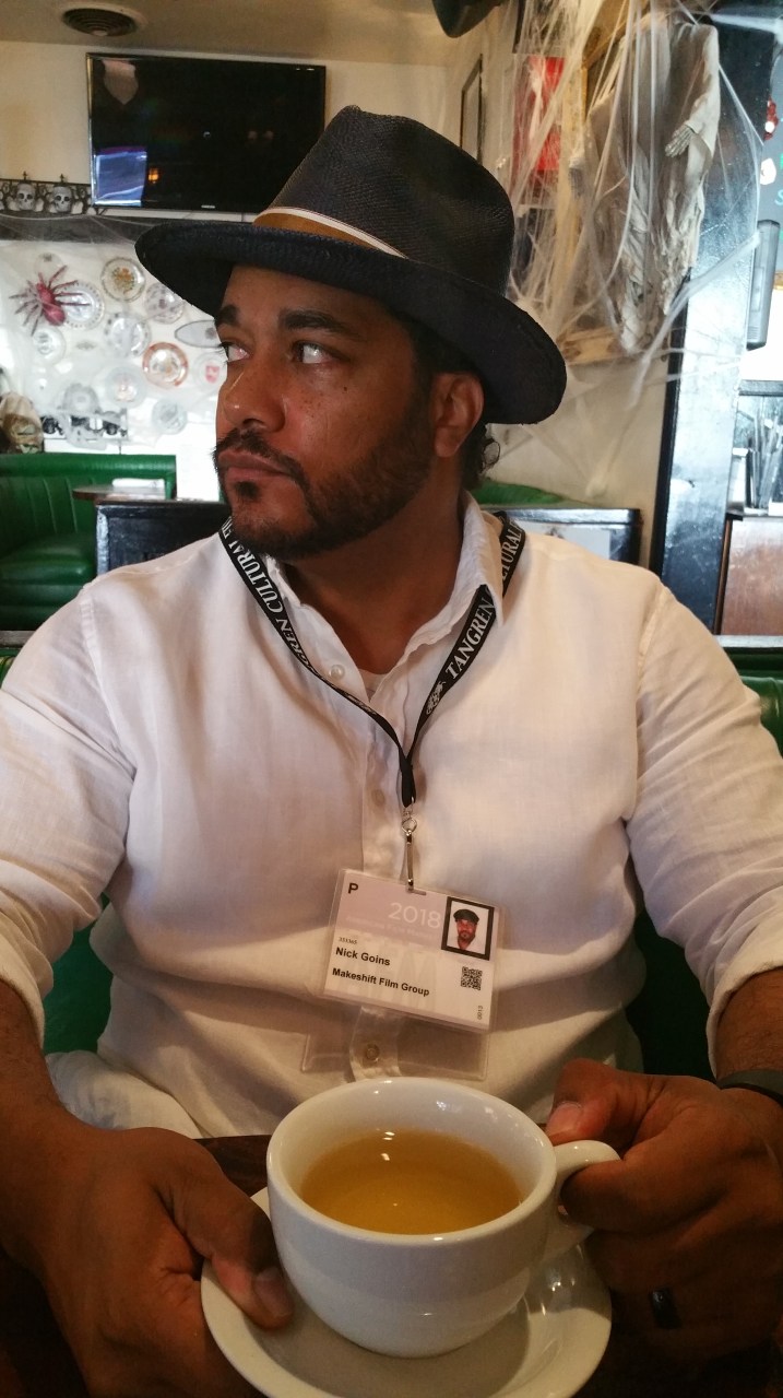 A man drinking tea in Santa Monica prior to heading to the American Film Market